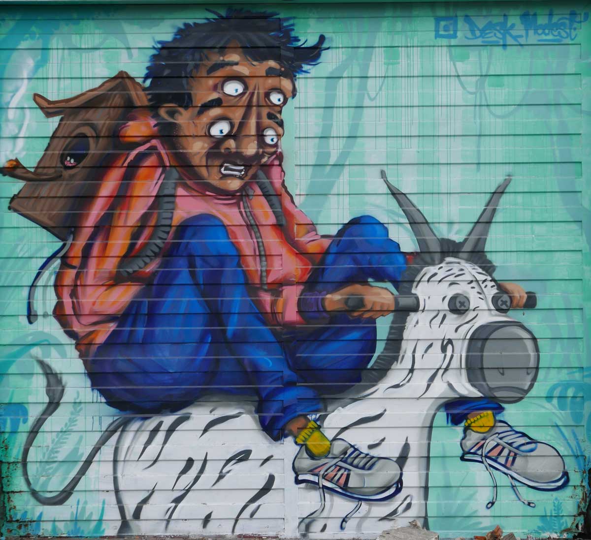 Garage door with double-eyed man. Street art in San Jose, Costa Rica