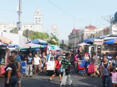 Street markets in 2a Calle Poniente in San Salvador. In the background the cathedral and Iglesia El Rosario can be seen